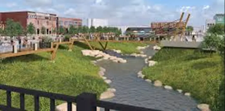 Cours d'eau renaturé en ville avec berges végétalisées et espace de divagation